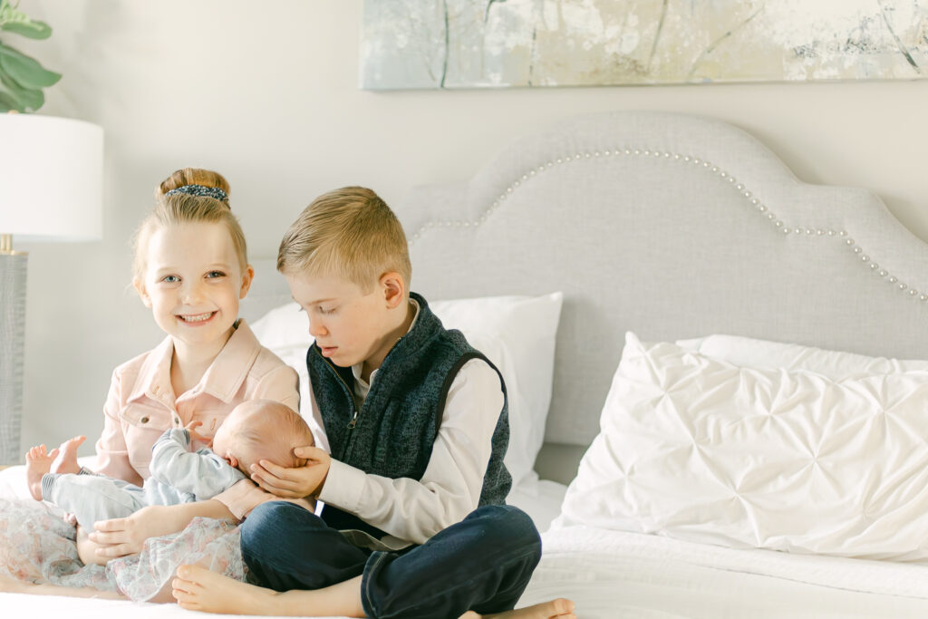 older brother and sister hold newborn baby brother in newborn photo session dayton ohio 