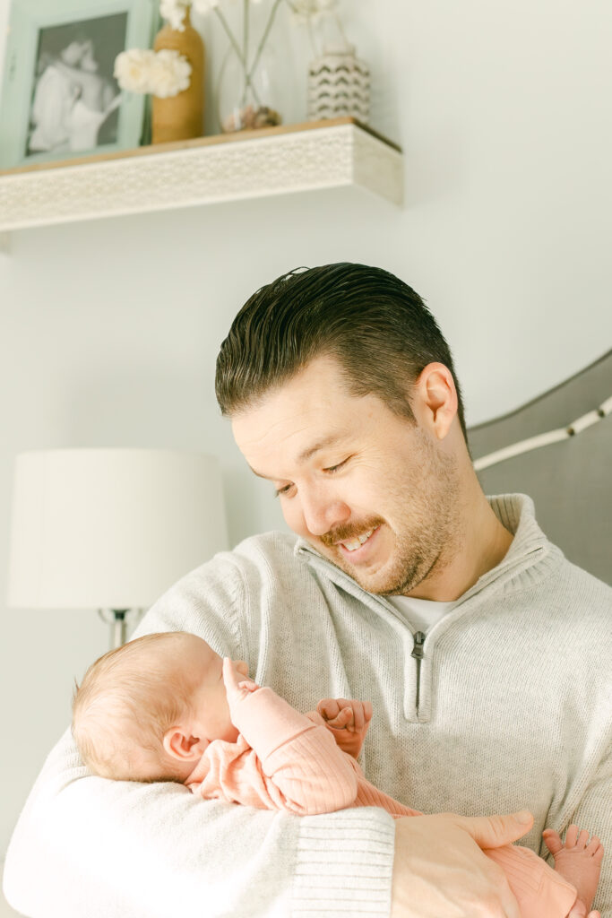 father looks at newborn daughter for dayton metro area photographer 