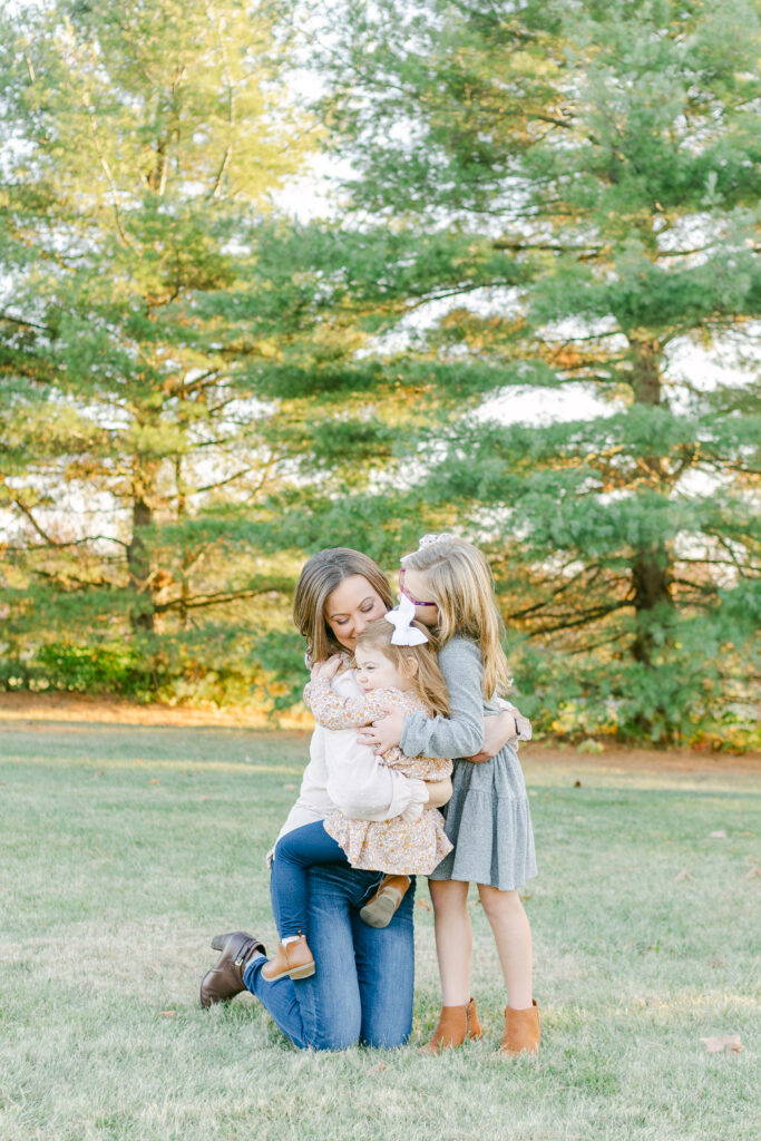 mother hugs two young daughters in dayton ohio park photo session