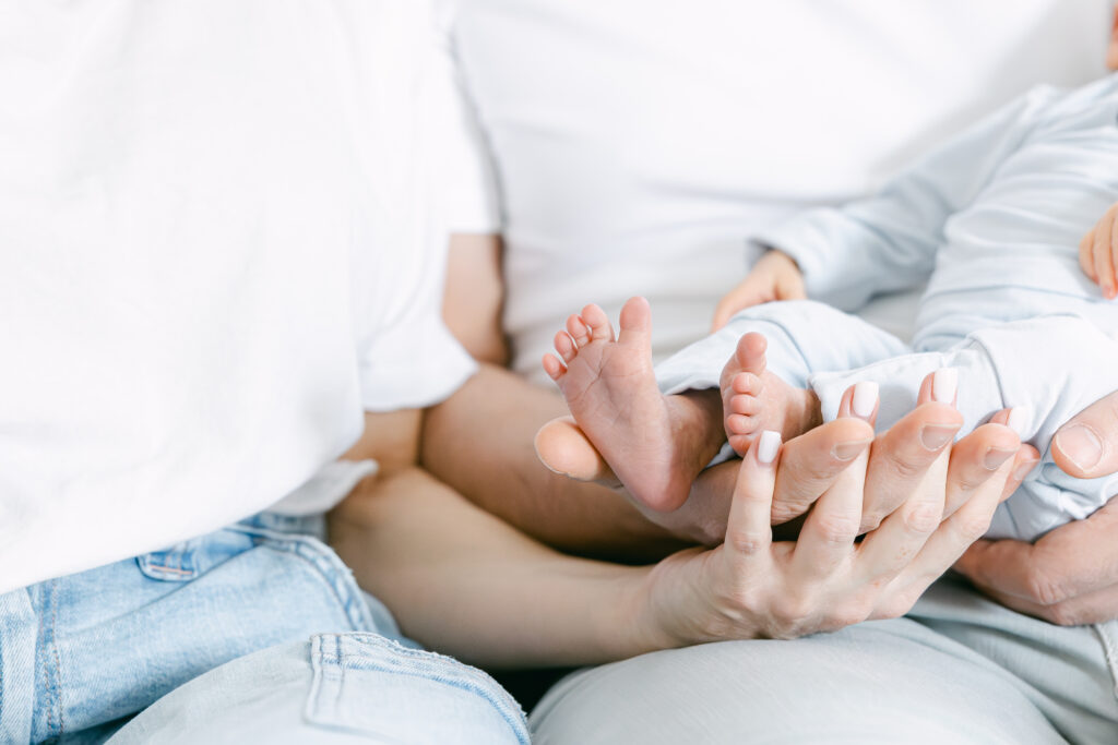 newborn baby boys feet in mom and dads hand in morrow ohio with newborn photographer