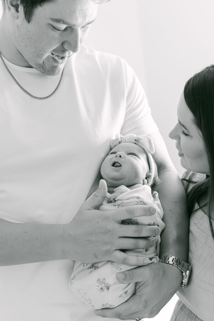 black and white dad holding baby girl for Lebanon ohio newborn photography session