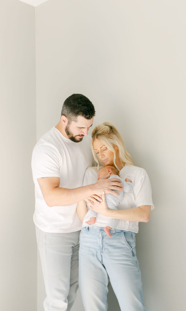 baby boy laying on mom sleeping as dads hand is on his back for cincinnati newborn photography session