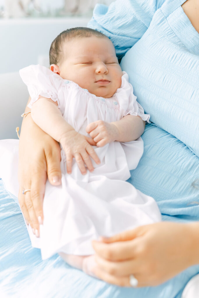 newborn baby girl in moms arms sleeping for in home newborn photography session in Lebanon Ohio