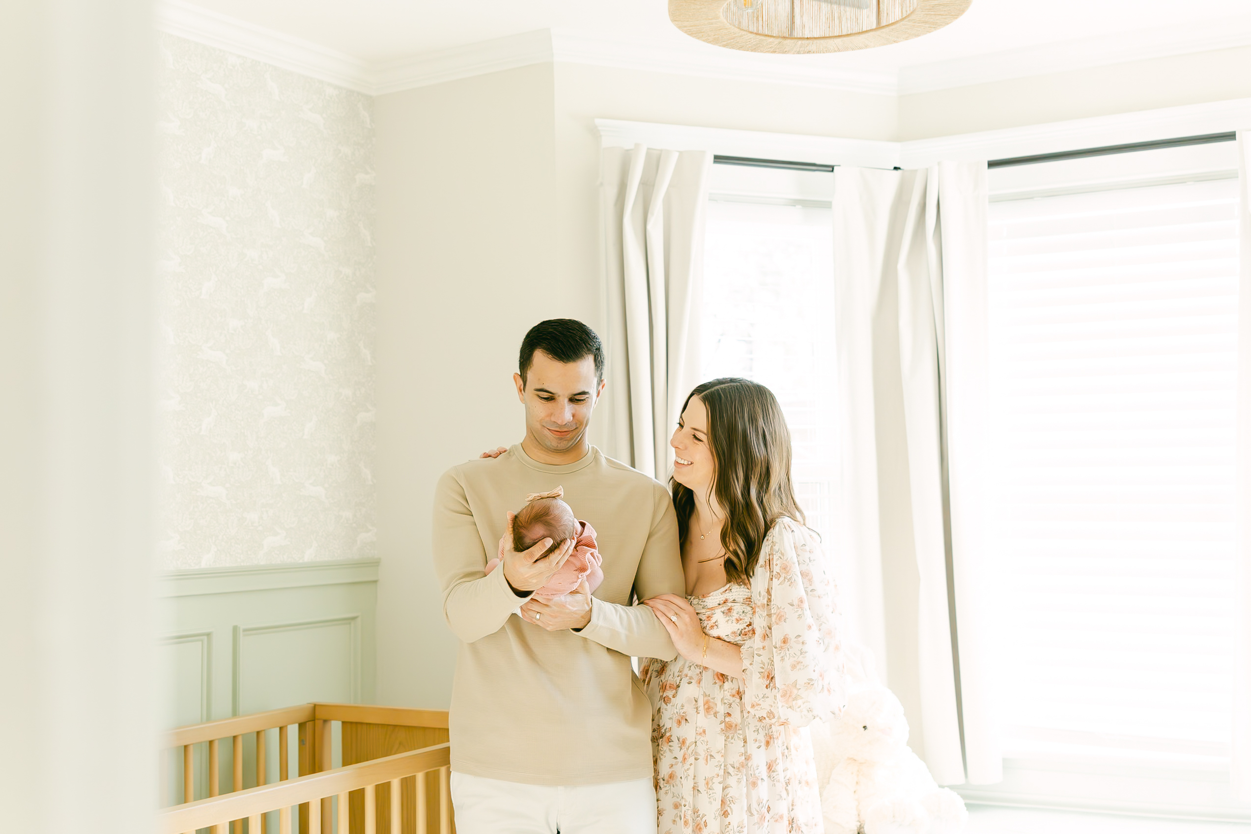 mom smiling at dad as dad with holding newborn baby girl for in home hyde park newborn session in cincinnati ohio